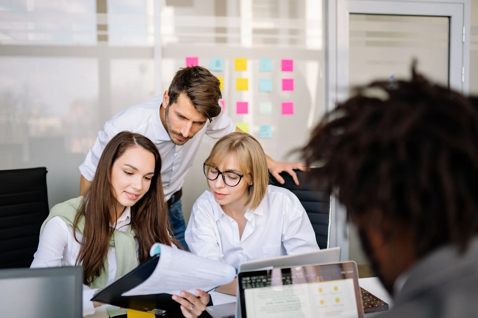 Hiring team reviewing a candidate shortlist Hiring team reviewing a candidate file together in a bright office, the kind of aligned team that keeps time to hire short