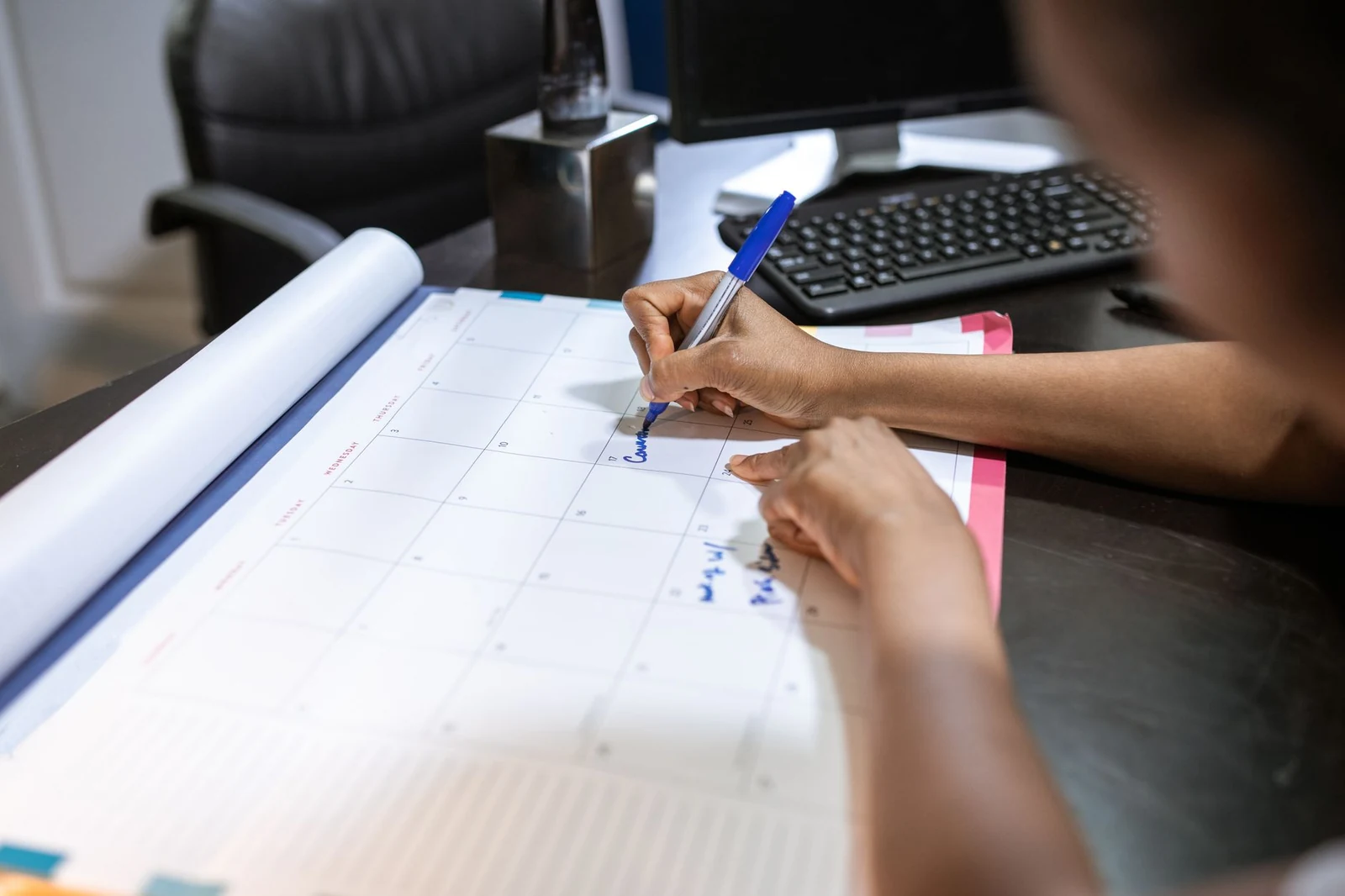 A desk calendar and notebook used to plan an interview schedule