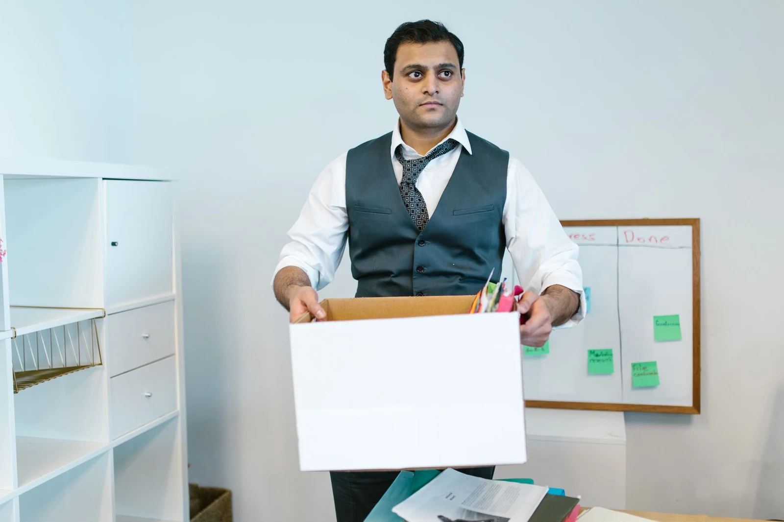 An employee packing a cardboard box on the last day at an office