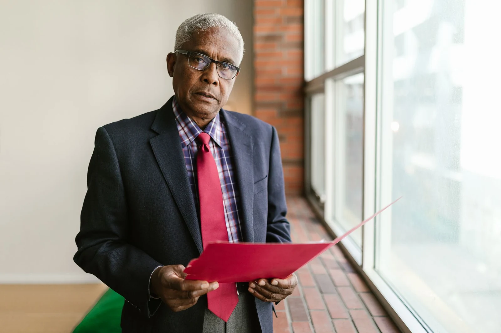 A business owner considering a hiring decision at an office window