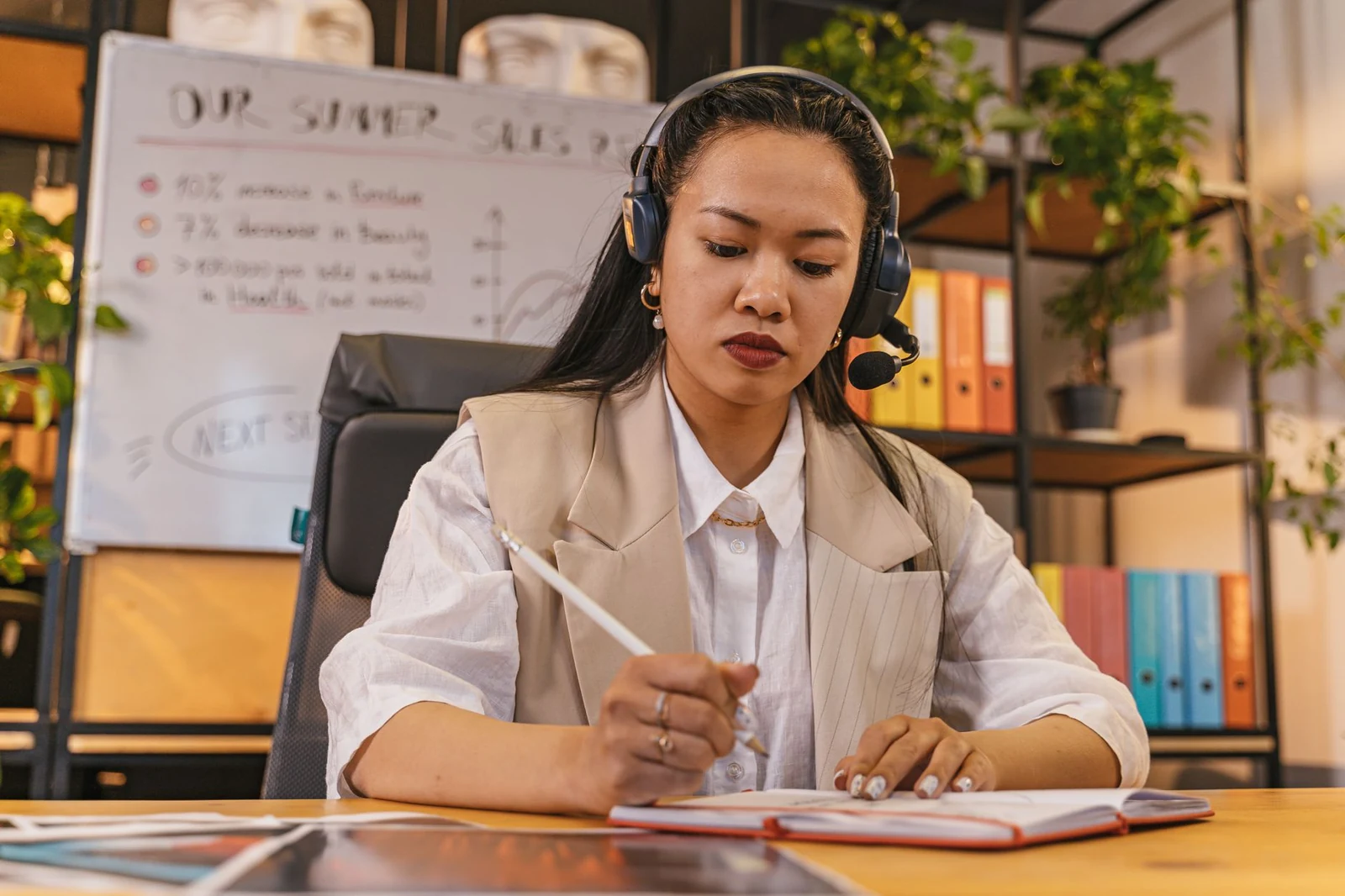 A recruiter taking notes during a phone call with a candidate