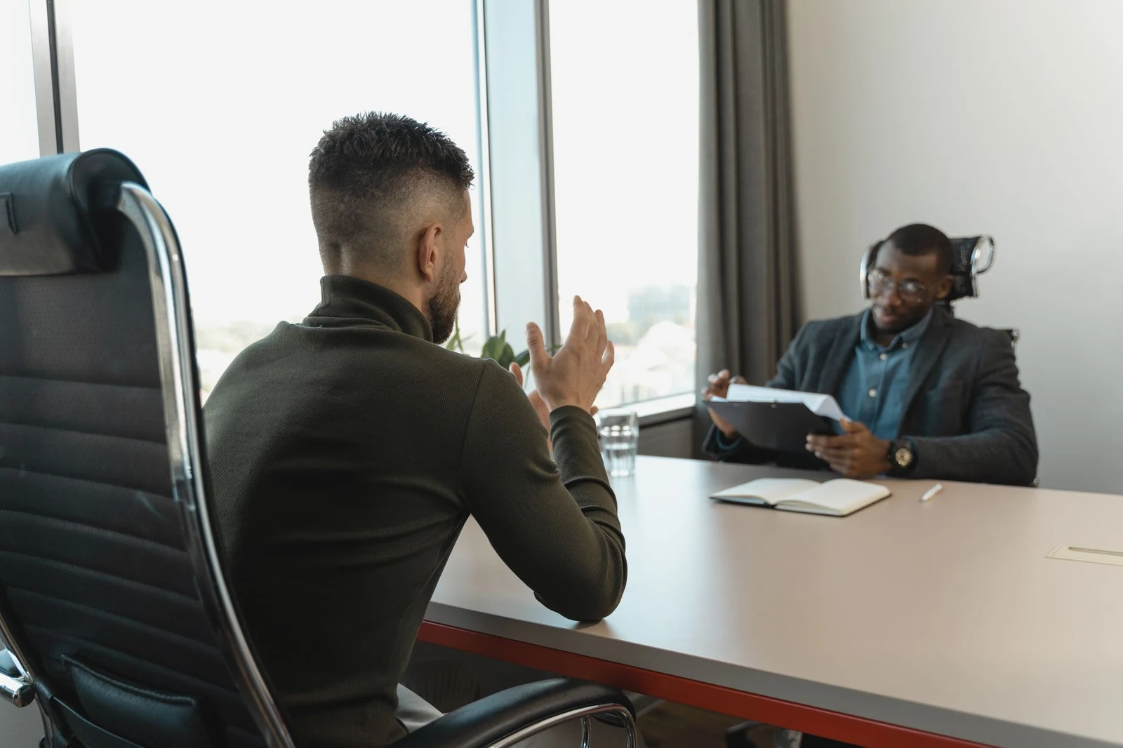 Two interviewers meeting a candidate across a table