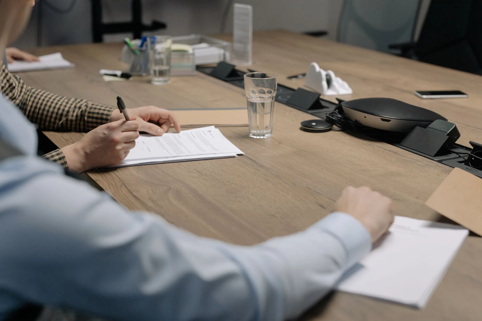 Legal documents and a pen on a boardroom table