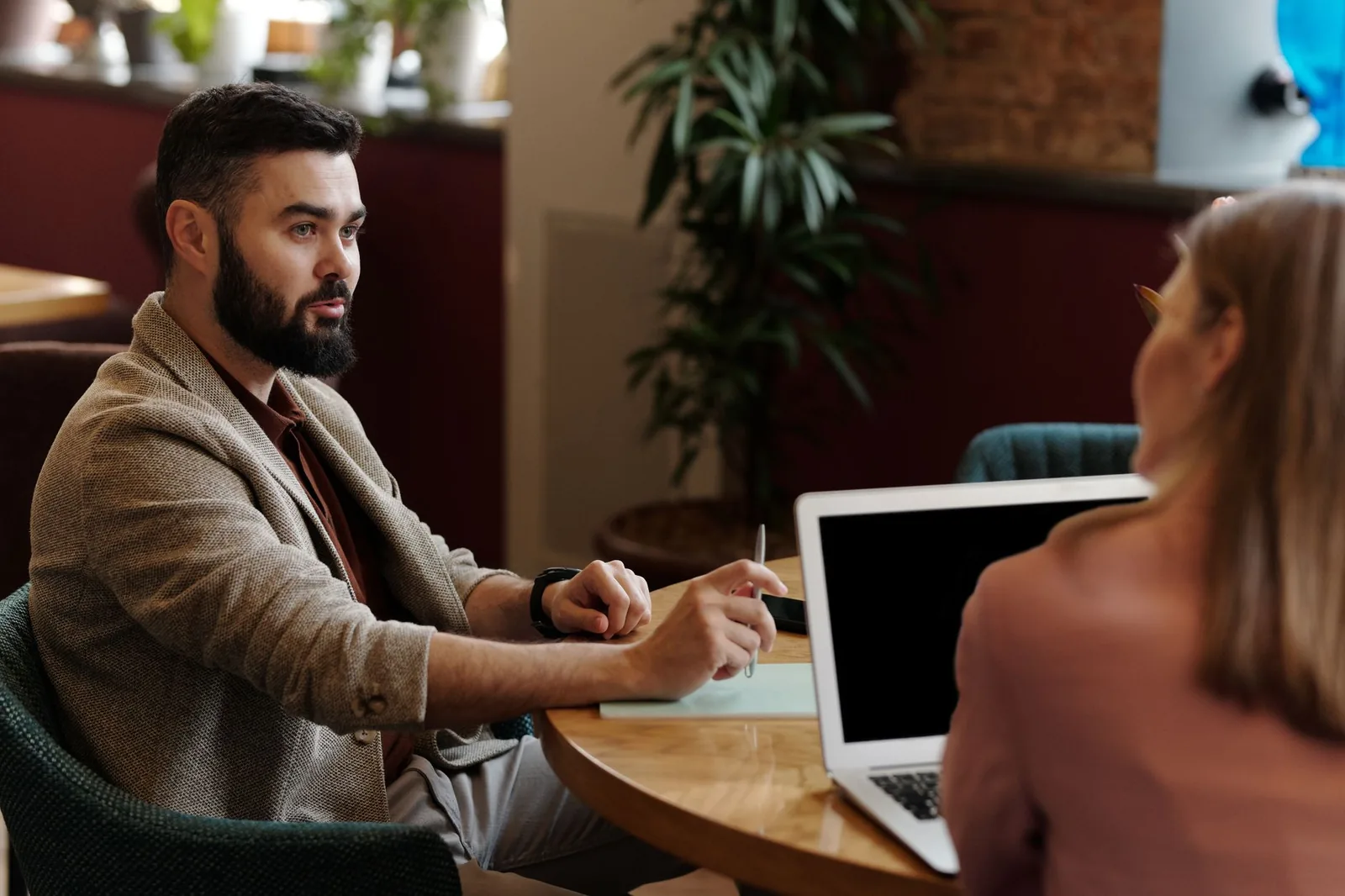A manager and new hire in a one-to-one check-in with notes on the table