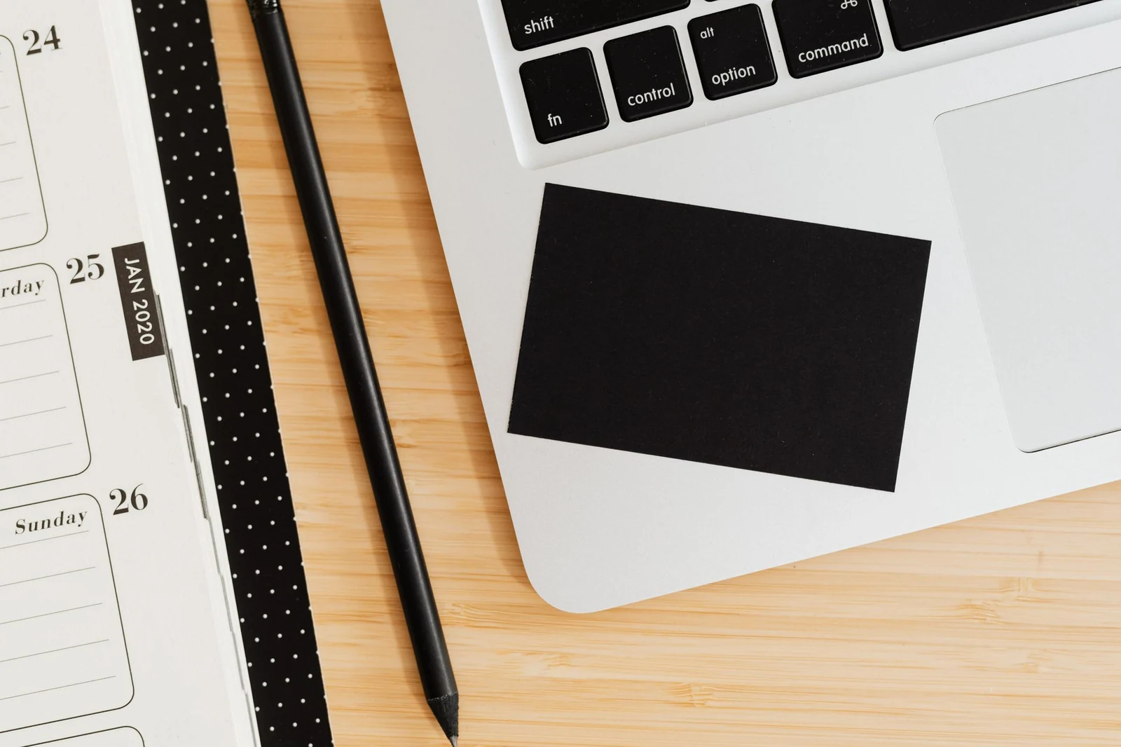 A prepared desk with laptop, notebook and welcome card waiting for a new employee