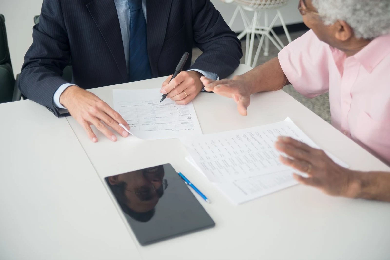 Two colleagues reviewing a printed document across a small meeting table