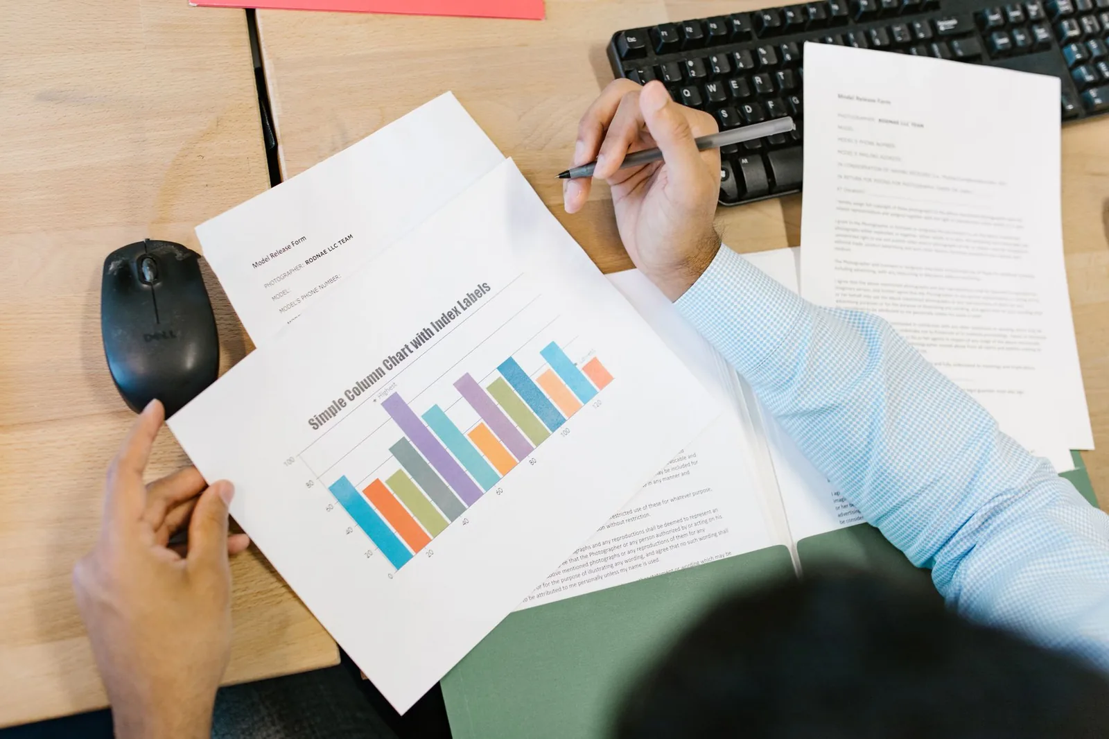 Two printed pay reports side by side on a desk with a pen and calculator