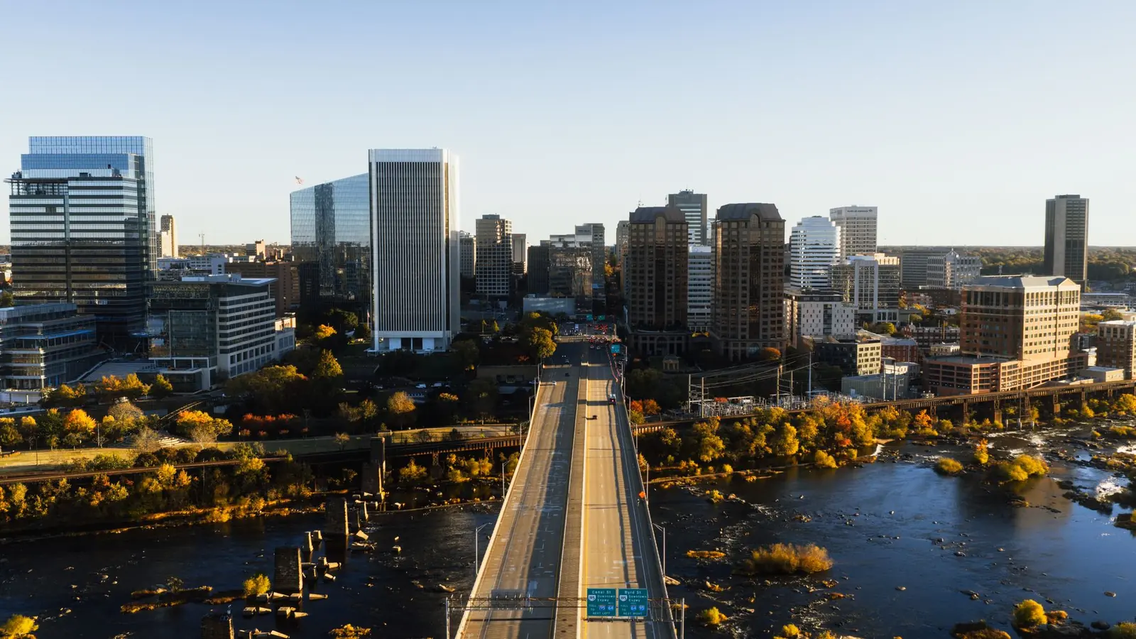 Aerial view of a growing mid-sized city beside a river with foothills behind