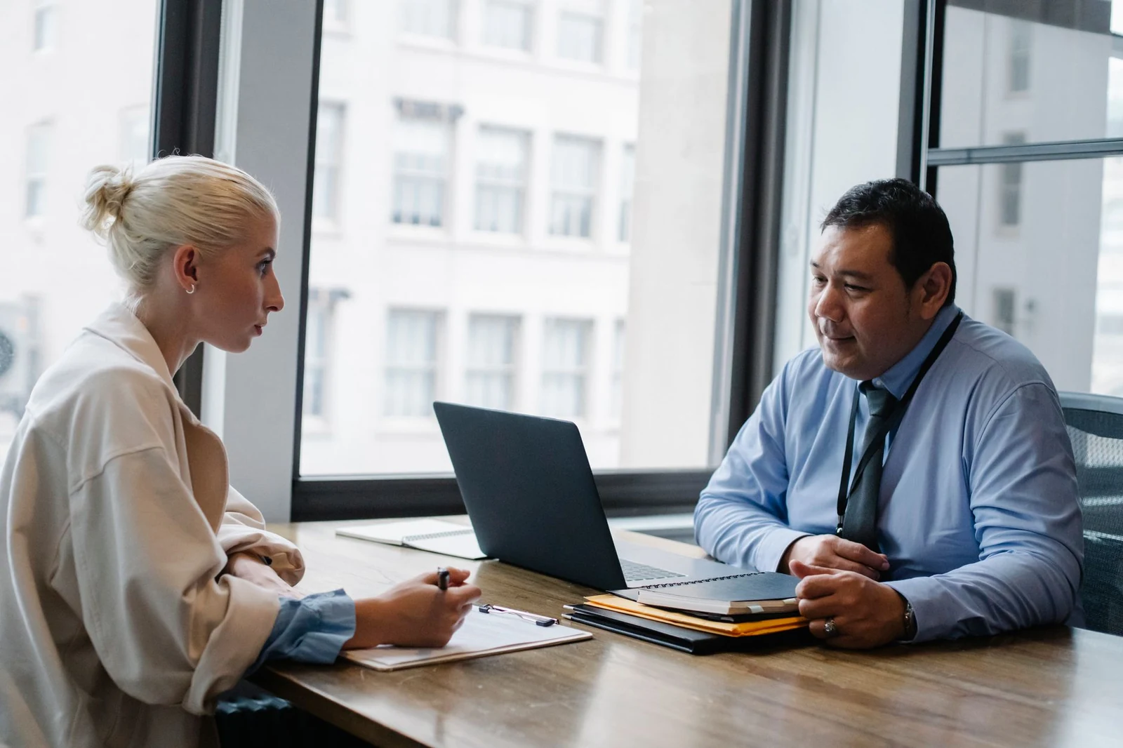Hiring manager meeting with a recruiter A hiring manager and a recruiter talking through a role at a table with a laptop and notes
