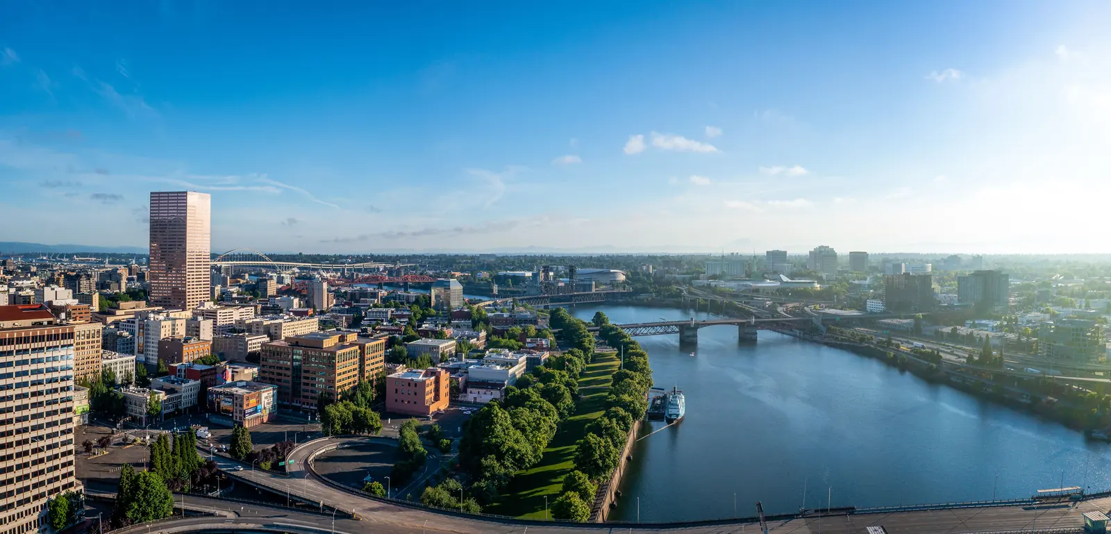 Downtown Portland, Oregon and the Willamette River Aerial view of downtown Portland, Oregon, with the pink US Bancorp Tower, a riverside park and bridges crossing the Willamette River under a blue sky