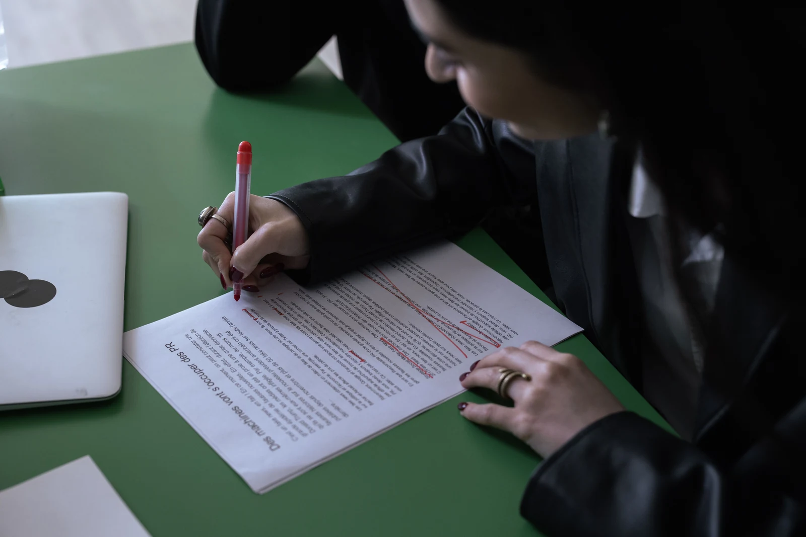 Editing a job description draft Hiring manager marking up a printed job description draft with a red pen
